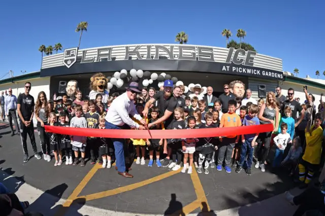 LA Kings Pickwick Ice Center Grand Re-Opening Media Event A man cutting the ribbon at a grand opening.