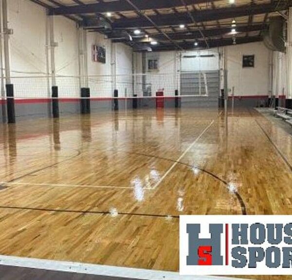 Indoor hardwood court with volleyball net.